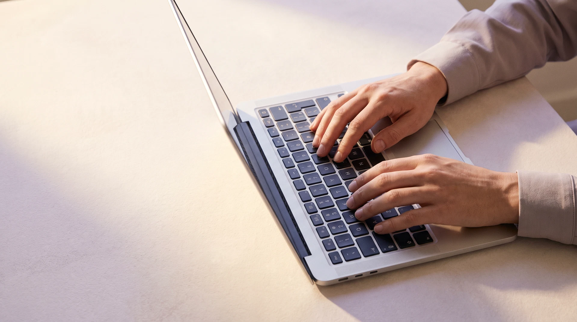 Hands beginning to type on a laptop